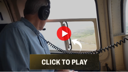 Whitney Tilson in a helicopter flying over a data center site.